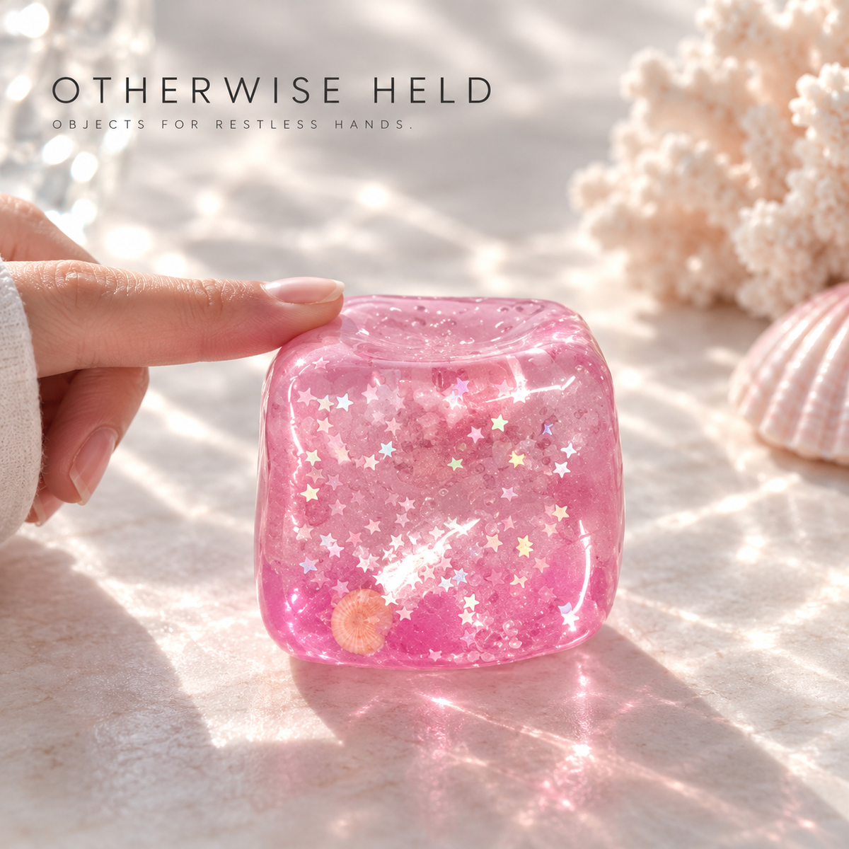 OH 06 Coral, fingertip pressing the translucent pink cube