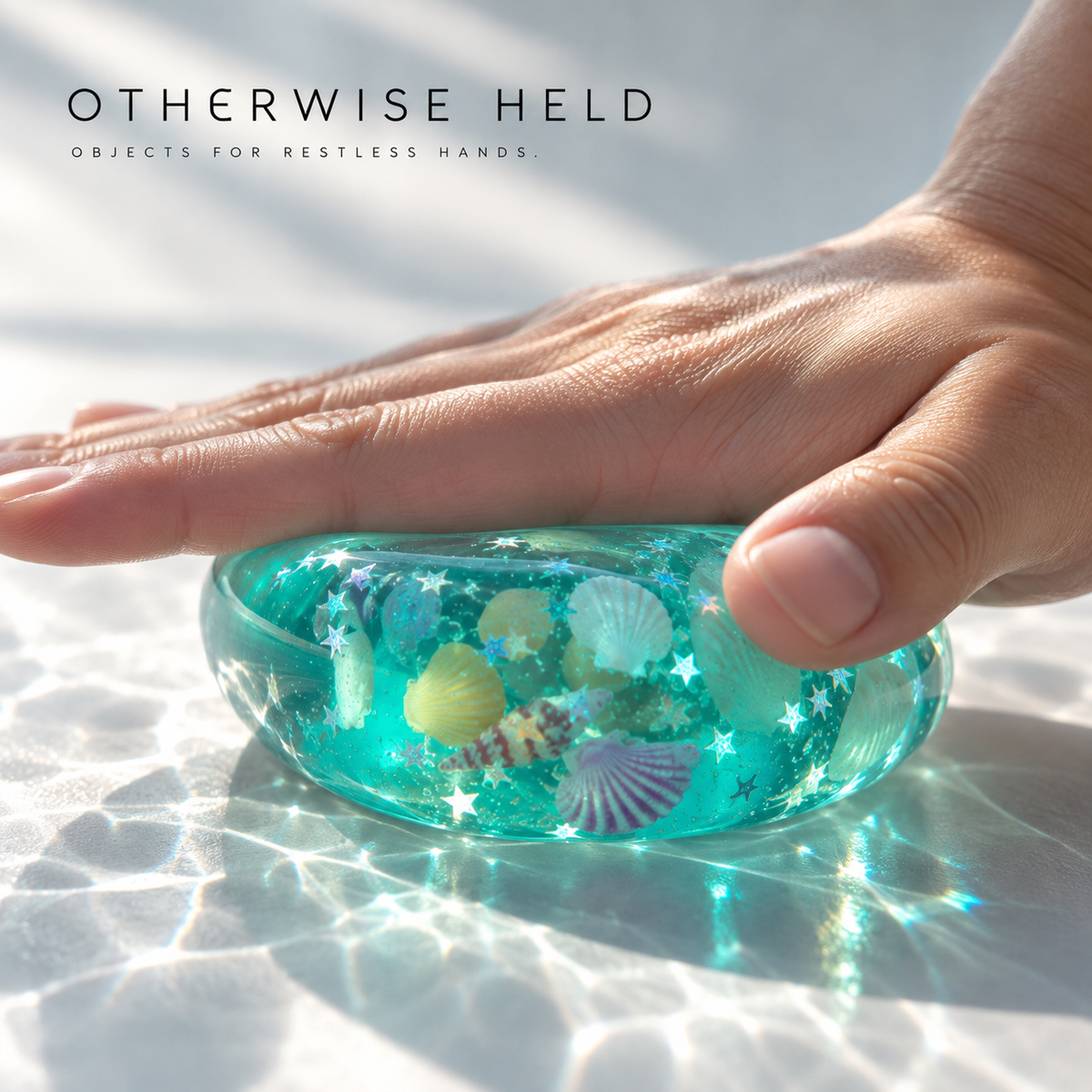OH 05 Ocean, hand pressing the translucent teal cube flat