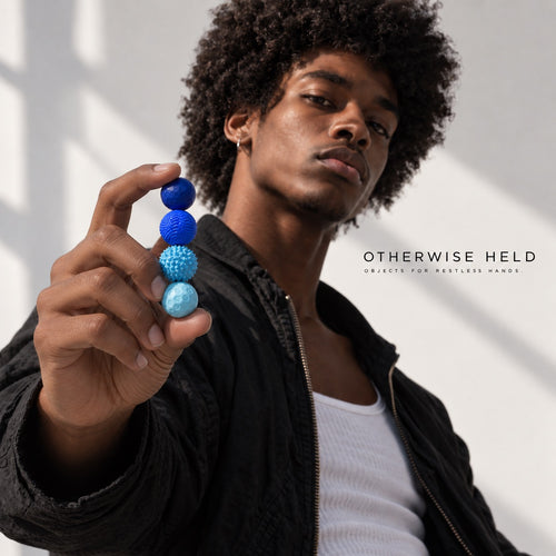 Man holding a column of blue OH 01 Magnetic spheres