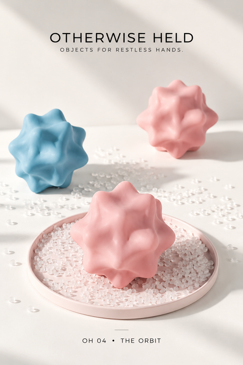 OH 04 The Orbit pink silicone massage ball on a tray with a blue and a pink ball behind
