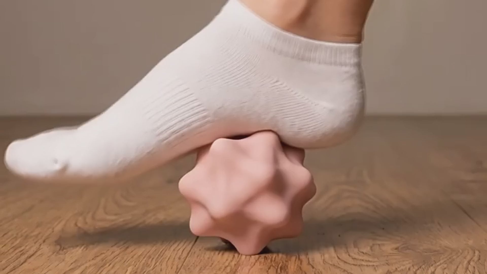 OH 04 The Orbit rolled underfoot: a pink silicone sphere turning under a socked foot on a wooden floor
